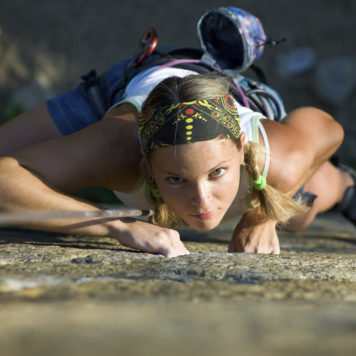 Vertical image of woman doing exercise on the mountain